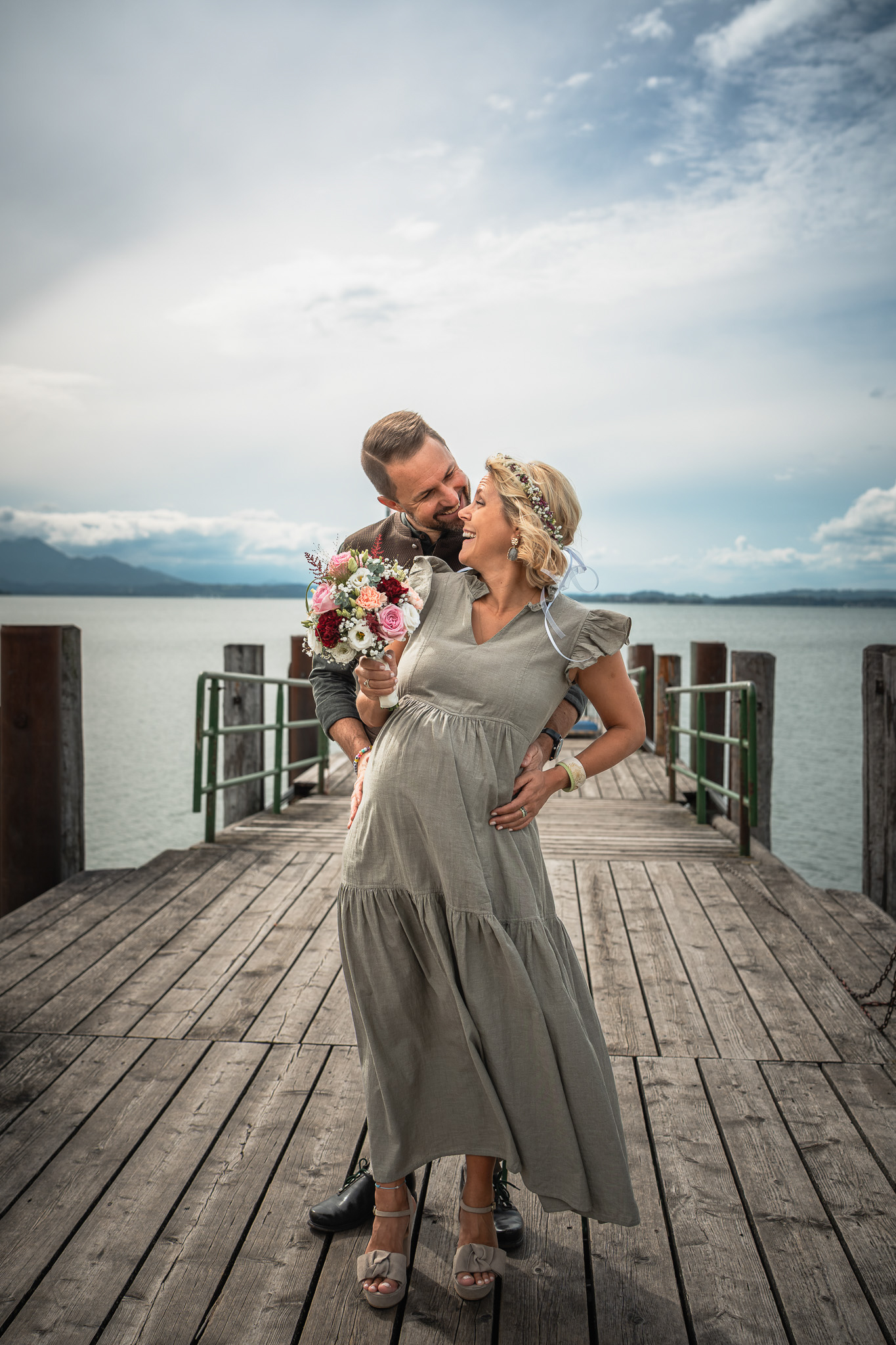 Brautpaar küsst sich auf dem Steg am Chiemsee während der Paarfotos in Chieming