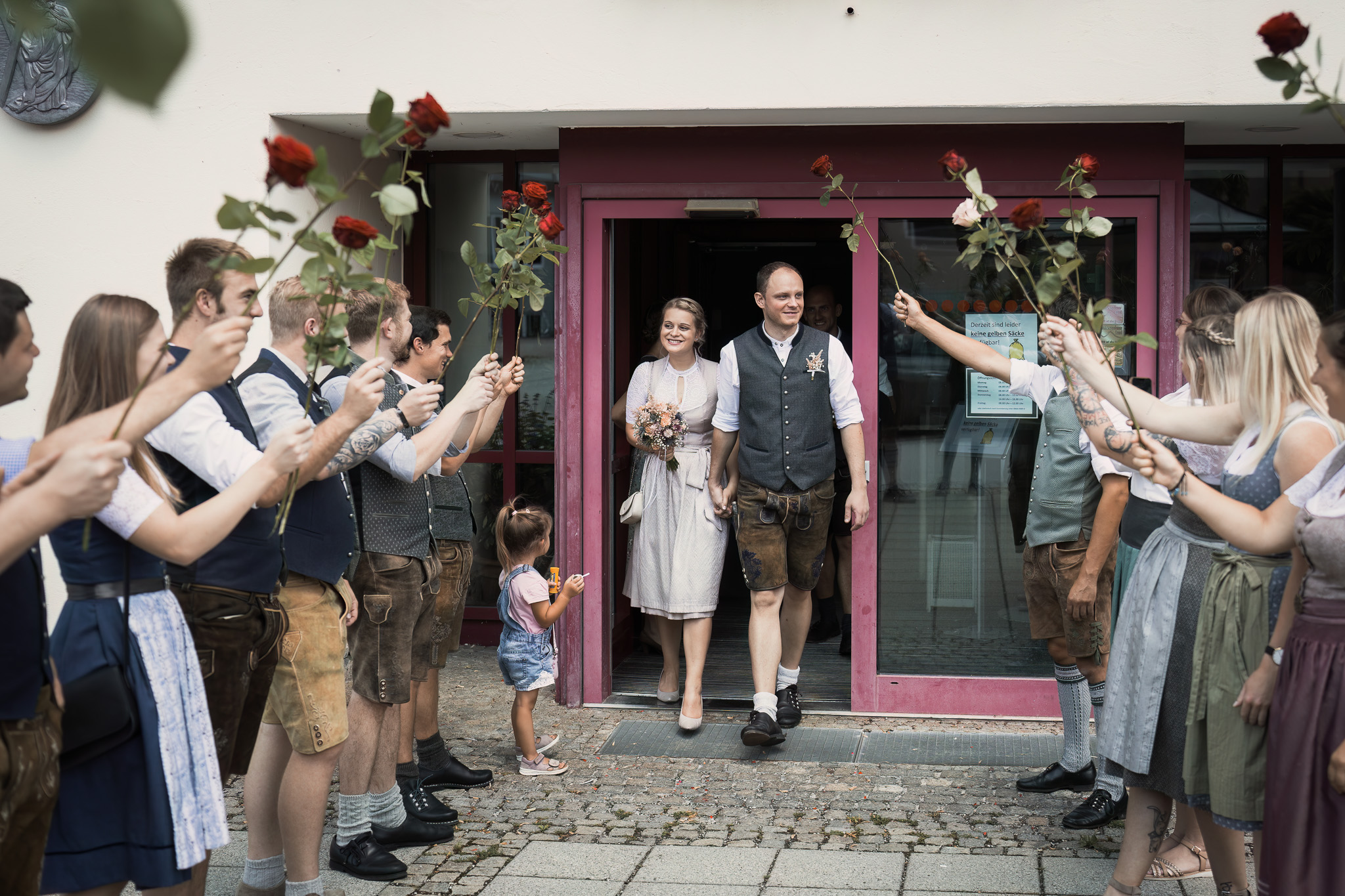Frisch verheiratetes Paar verlässt das Standesamt Teisendorf durch ein Spalier aus Rosen