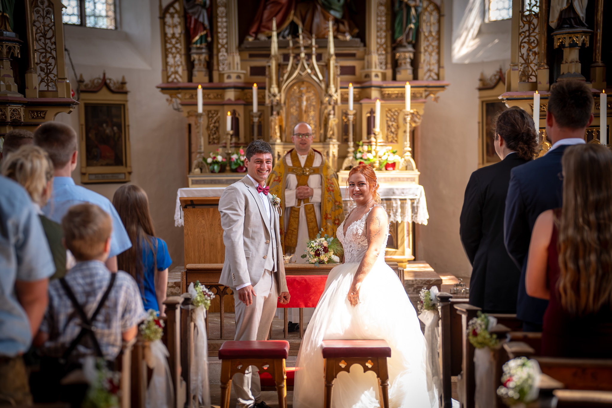 Braut und Bräutigam stehen während der kirchlichen Trauung vor dem Altar.