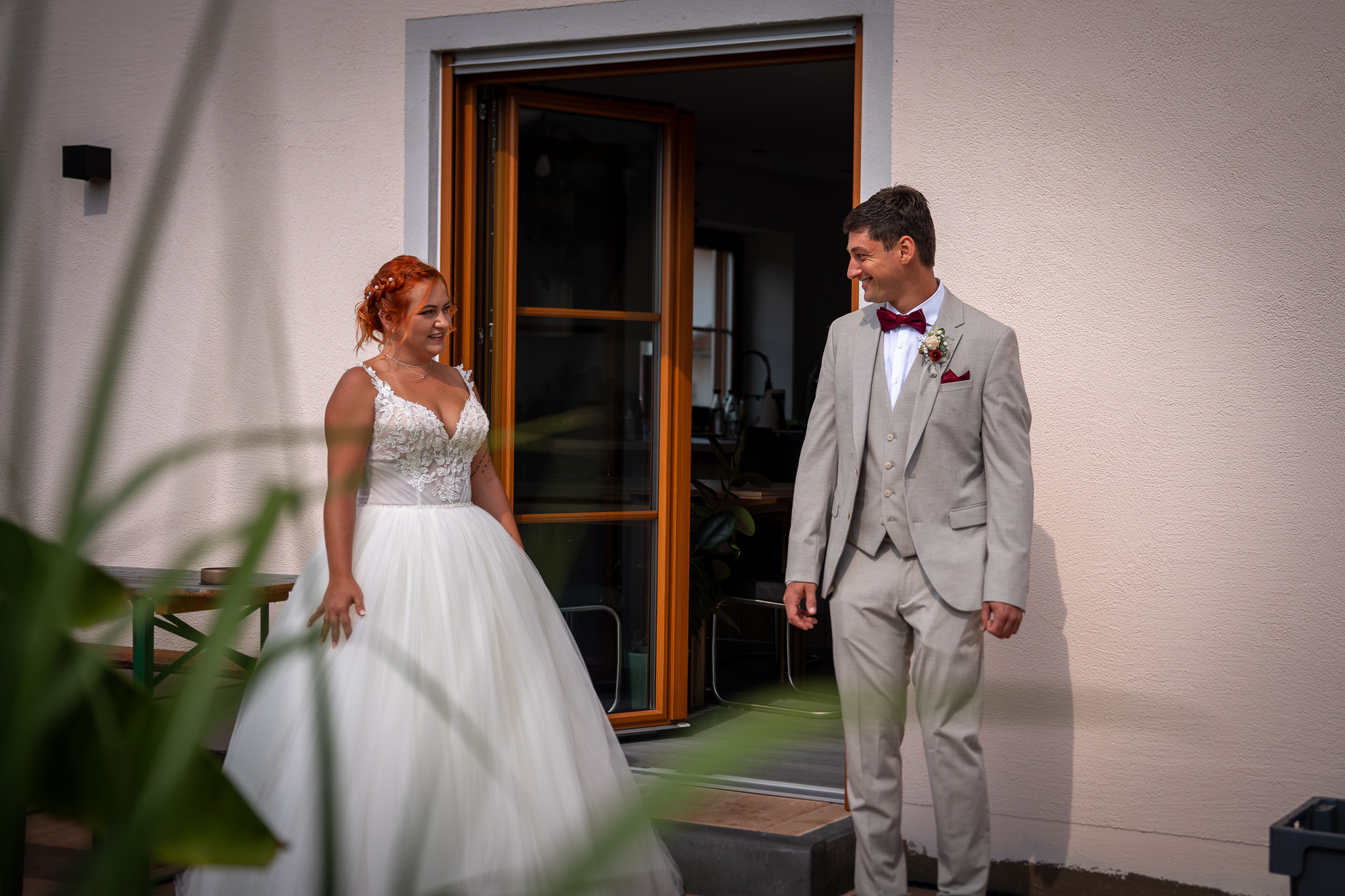 First Look auf der Terrasse: Braut und Bräutigam sehen sich zum ersten Mal in ihrer Hochzeitskleidung.