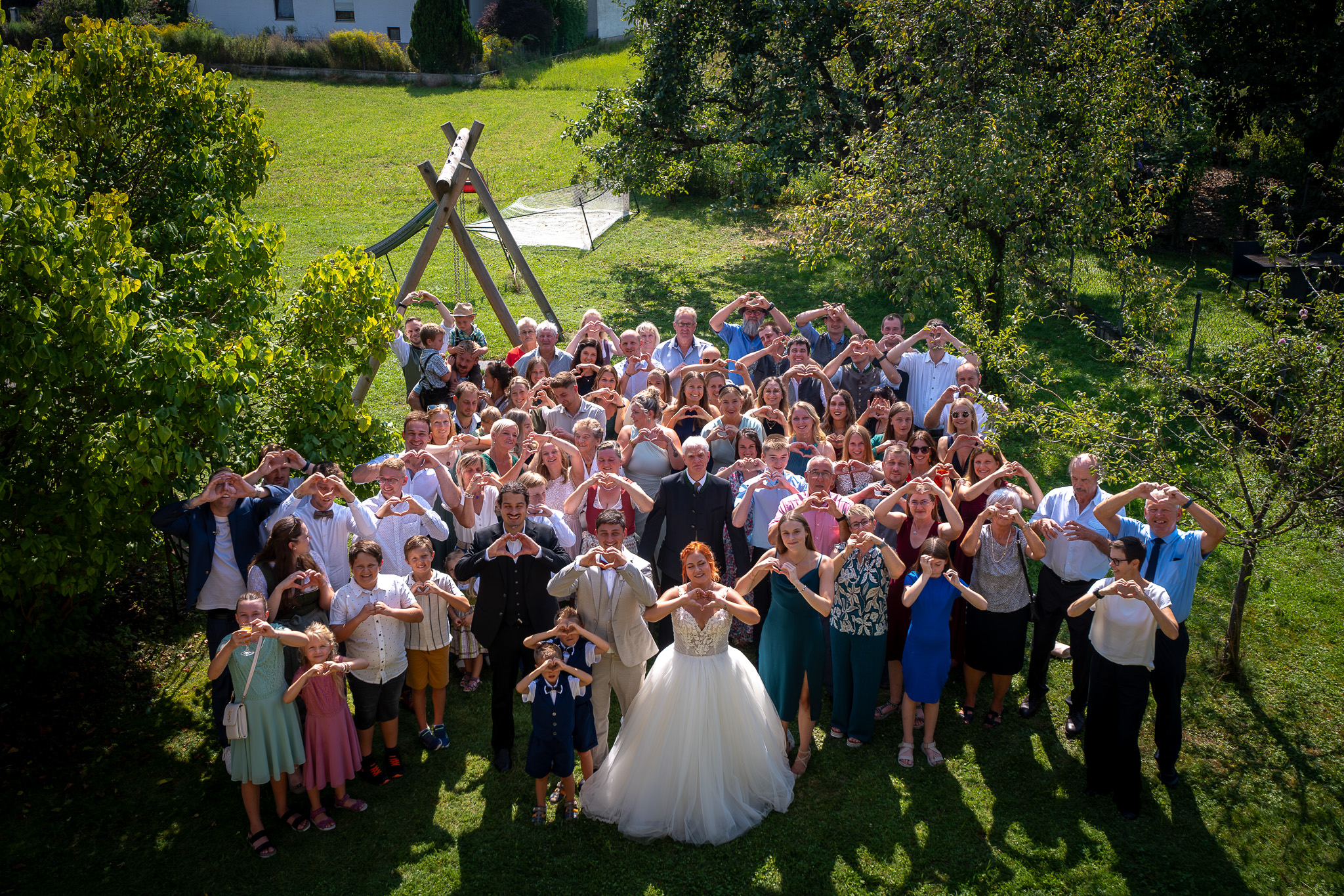 Gruppenfoto der gesamten Hochzeitsgesellschaft aus erhöhter Perspektive.
