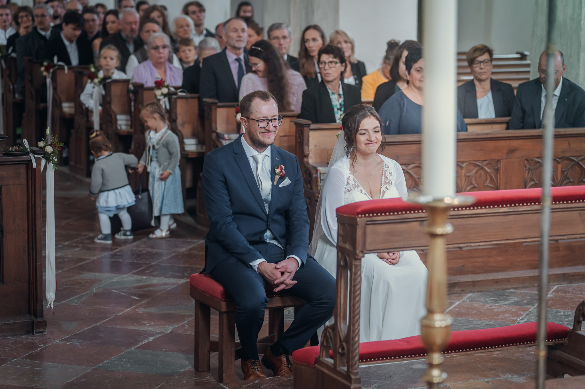 Das Brautpaar sitzt während der kirchlichen Trauung vor dem Altar im Kloster Seeon.