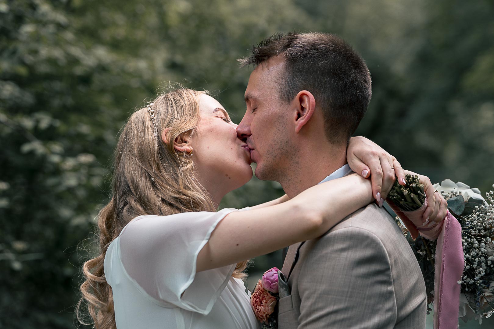 Brautpaar küsst sich im Grünen – emotionale Hochzeitsfotografie | Lindl Photography Brautpaar küsst sich innig draußen im Grünen – ein natürlicher Hochzeitsmoment