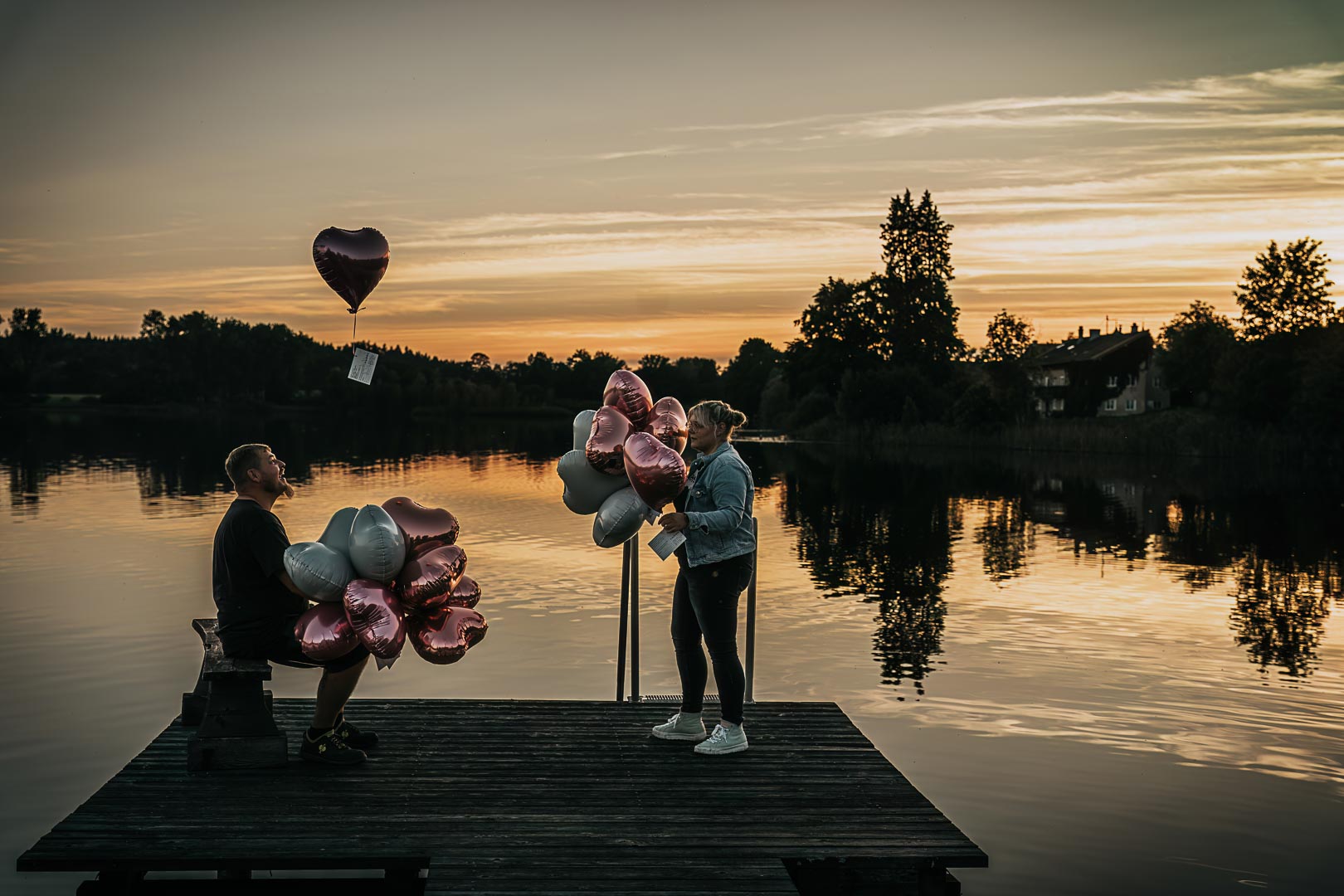 Brautpaar mit Luftballons am See bei Sonnenuntergang | Lindl Photography Brautpaar mit Luftballons auf einem Steg am See im Abendlicht.
