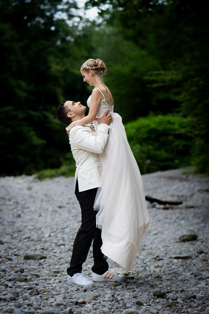 Natürliches Brautpaarshooting im Grünen – Hochzeitsfotografie | Lindl Photography Bräutigam hebt seine Braut beim Paarshooting im Grünen hoch – ganz ohne steife Posen.