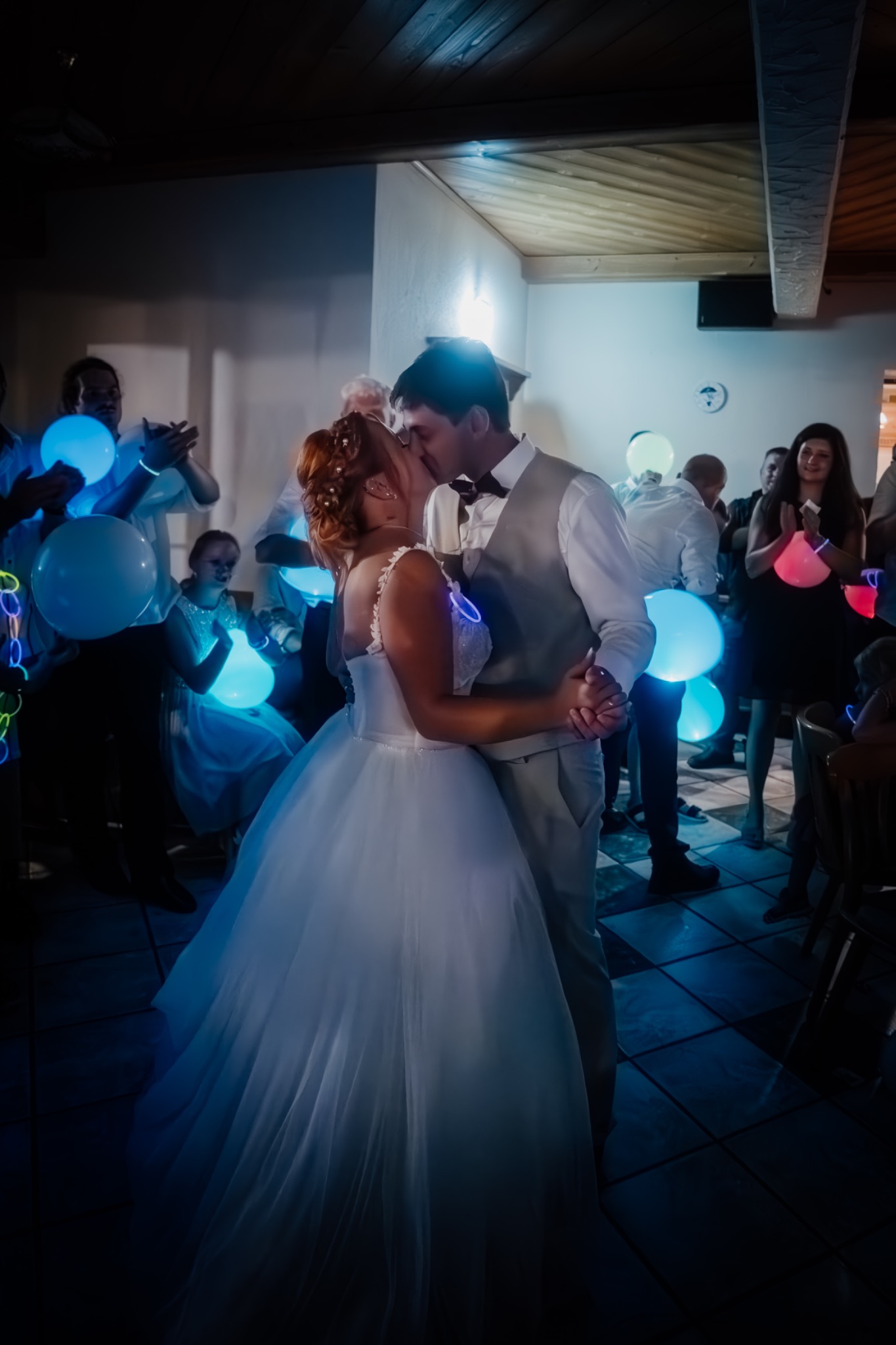 Brautpaar küsst sich beim Hochzeitstanz mit leuchtenden Ballons