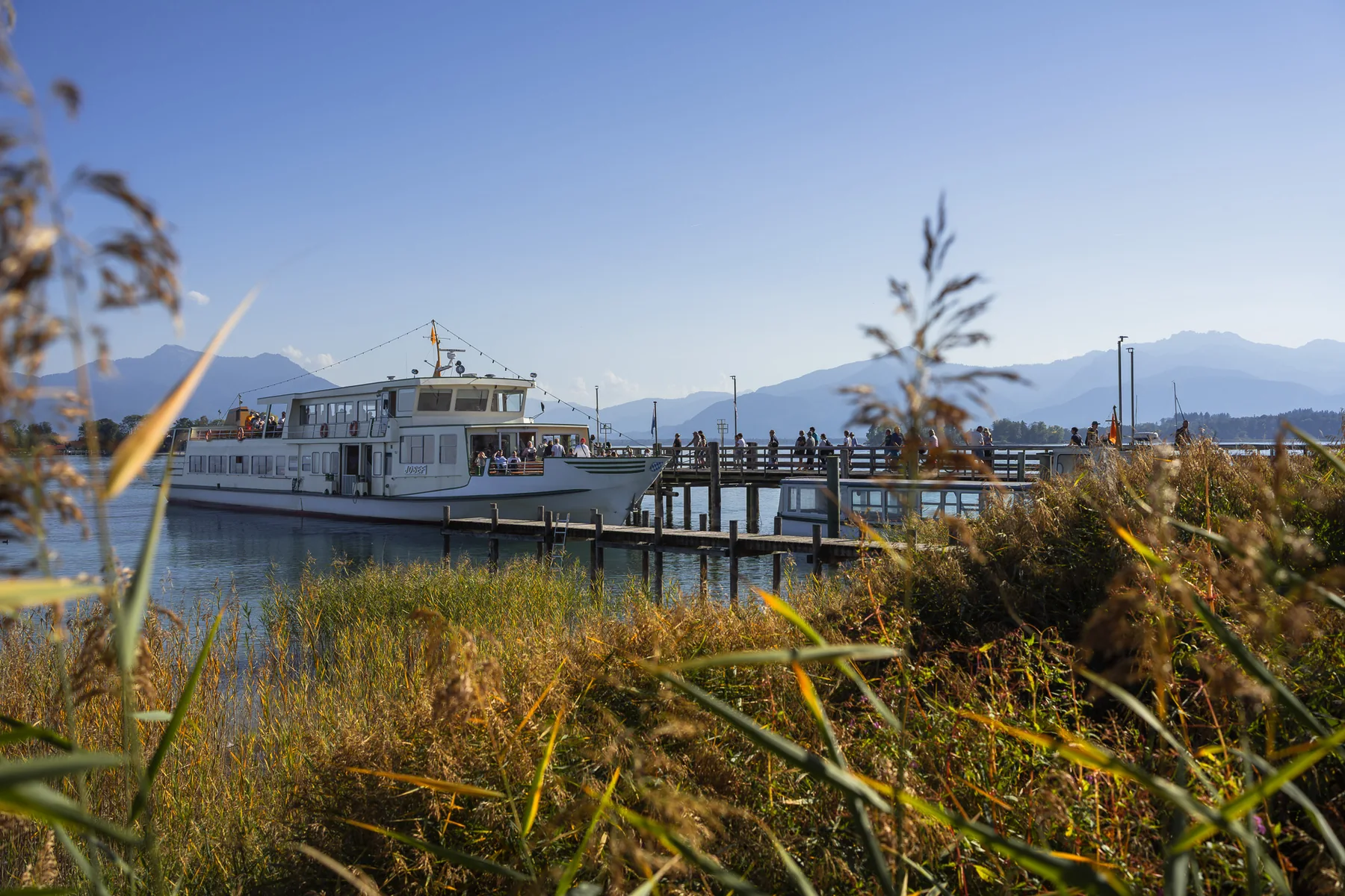 Chiemsee-Schifffahrt am Dampfersteg in Gstadt mit den Chiemgauer Alpen im Hintergrund