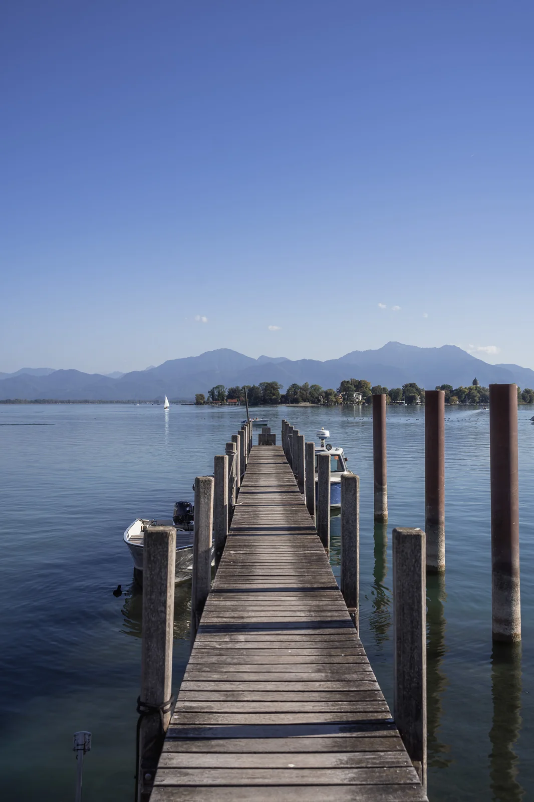 Holzsteg in Gstadt am Chiemsee mit Blick über den See zu den Chiemgauer Alpen