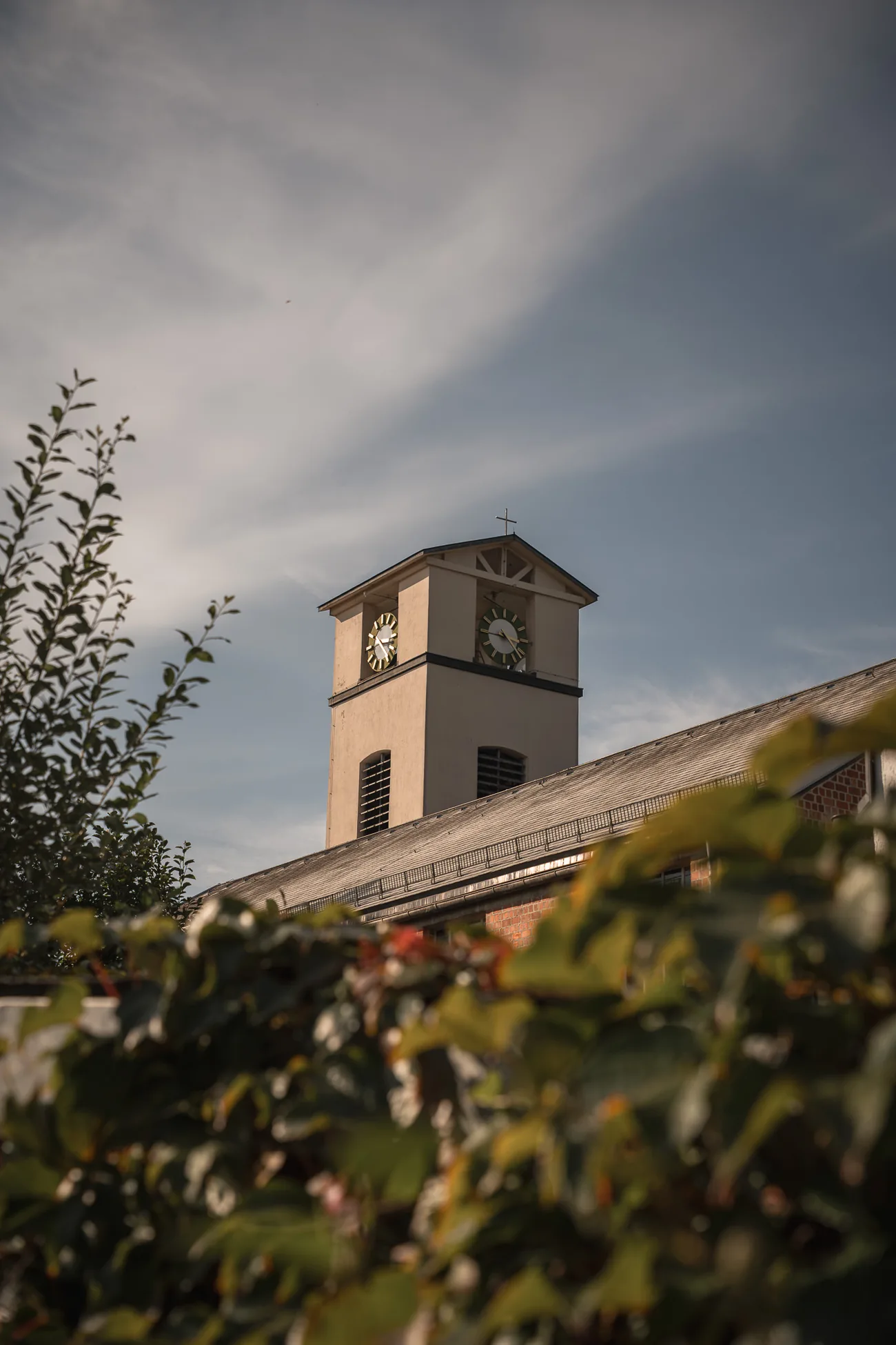 Kirchturm über den Bäumen im Zentrum von Traunreut