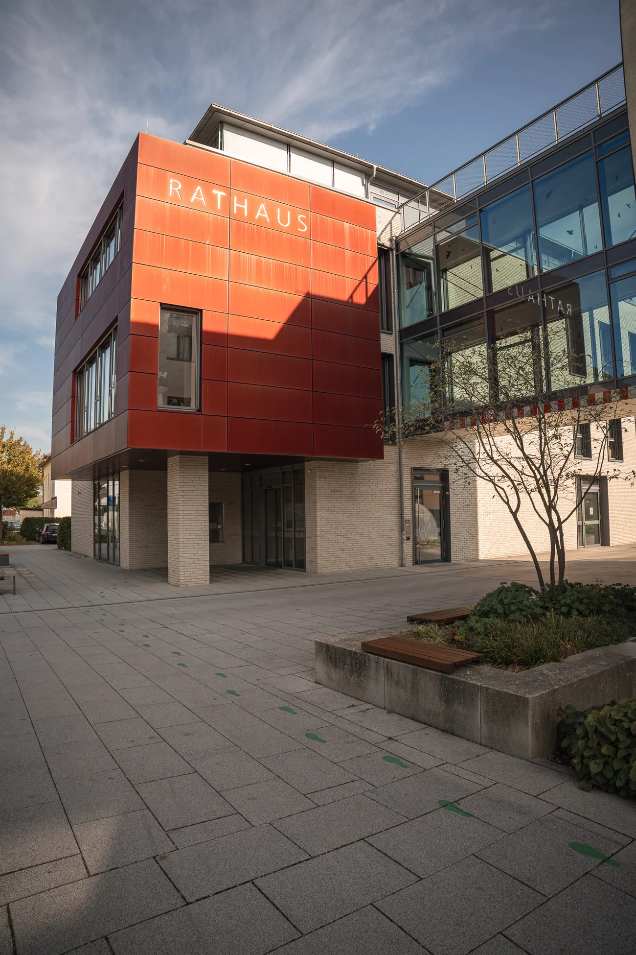 Eingang des Rathauses Traunreut mit roter Fassade und Glasfront