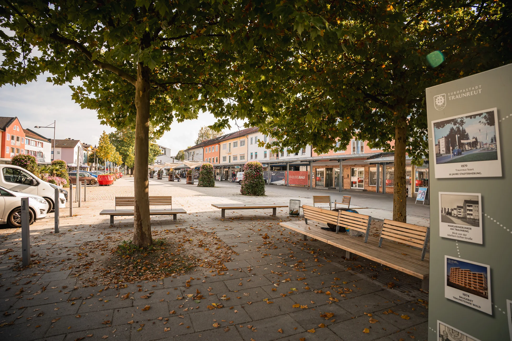 Baumbestandener Platz mit Sitzbänken im Zentrum von Traunreut